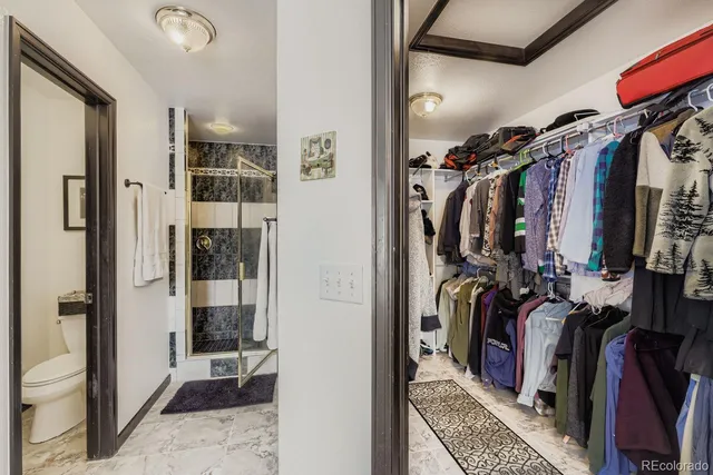 a view of walk in closet with clothes and shoes