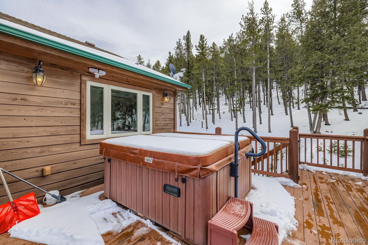 296 Desperado Road Bailey, CO 80421 - Photo 32 of 38 a view of a patio with table and chairs with wooden floor and fence