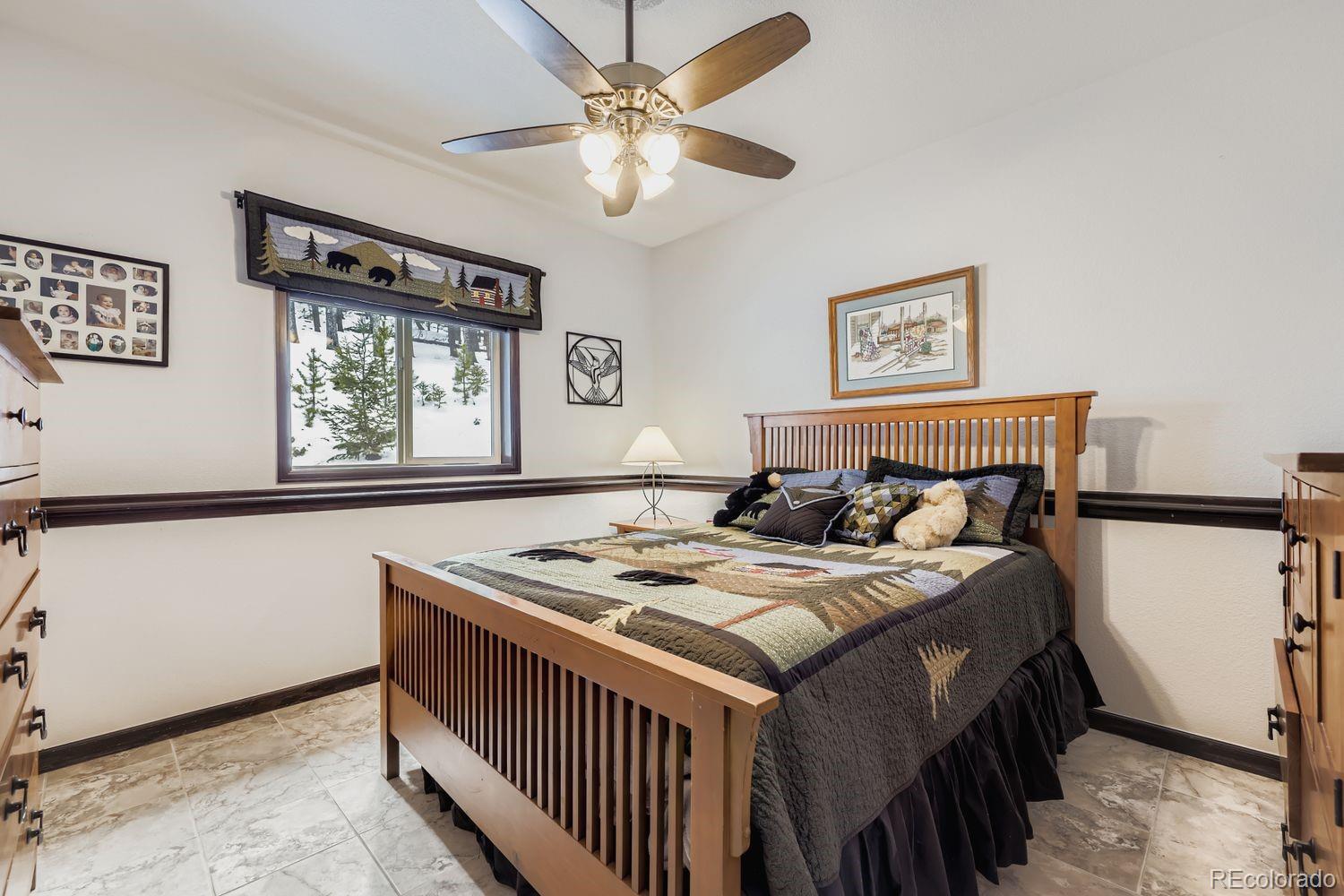 296 Desperado Road Bailey, CO 80421 - Photo 4 of 37 a bedroom with a bed a window and a dresser