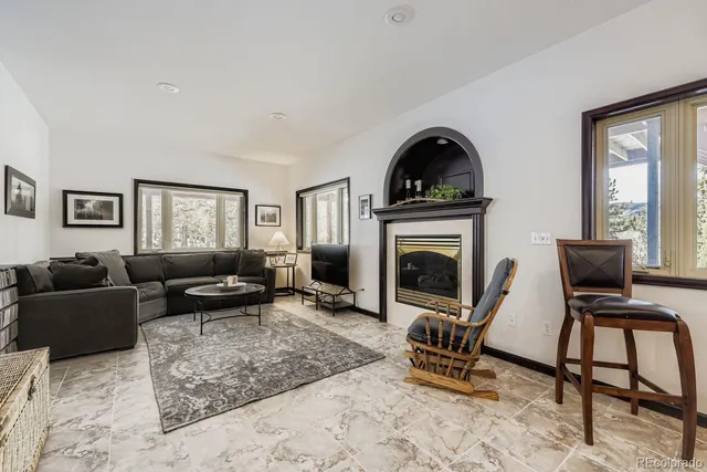 a living room with furniture a fireplace and a flat screen tv