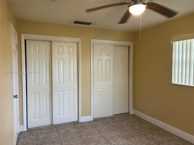 an empty room with window and bathroom