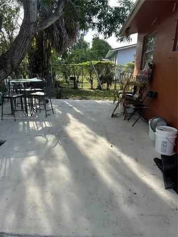 a view of a patio with table and chairs and potted plants