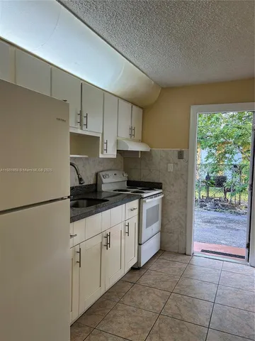 a kitchen with a sink window and cabinets