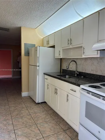 a kitchen with a refrigerator a stove a microwave and cabinets
