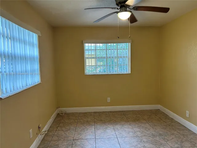 a view of a room with a window and a ceiling fan