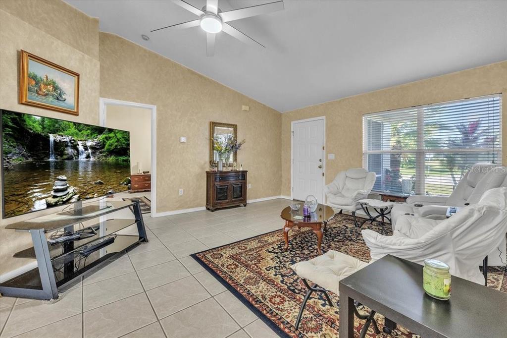 25313 Durango Court Punta Gorda, FL 33955 - Photo 3 of 34 a living room with furniture and a floor to ceiling window