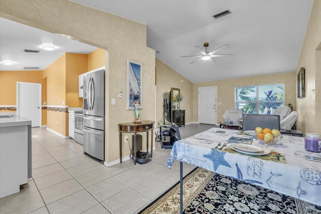 25313 Durango Court Punta Gorda, FL 33955 - Photo 6 of 34 a kitchen with stainless steel appliances kitchen island granite countertop a refrigerator a stove a dining table and chairs with wooden floor