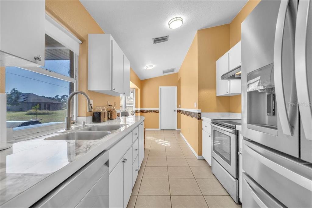 25313 Durango Court Punta Gorda, FL 33955 - Photo 7 of 34 a large kitchen with granite countertop a sink and cabinets