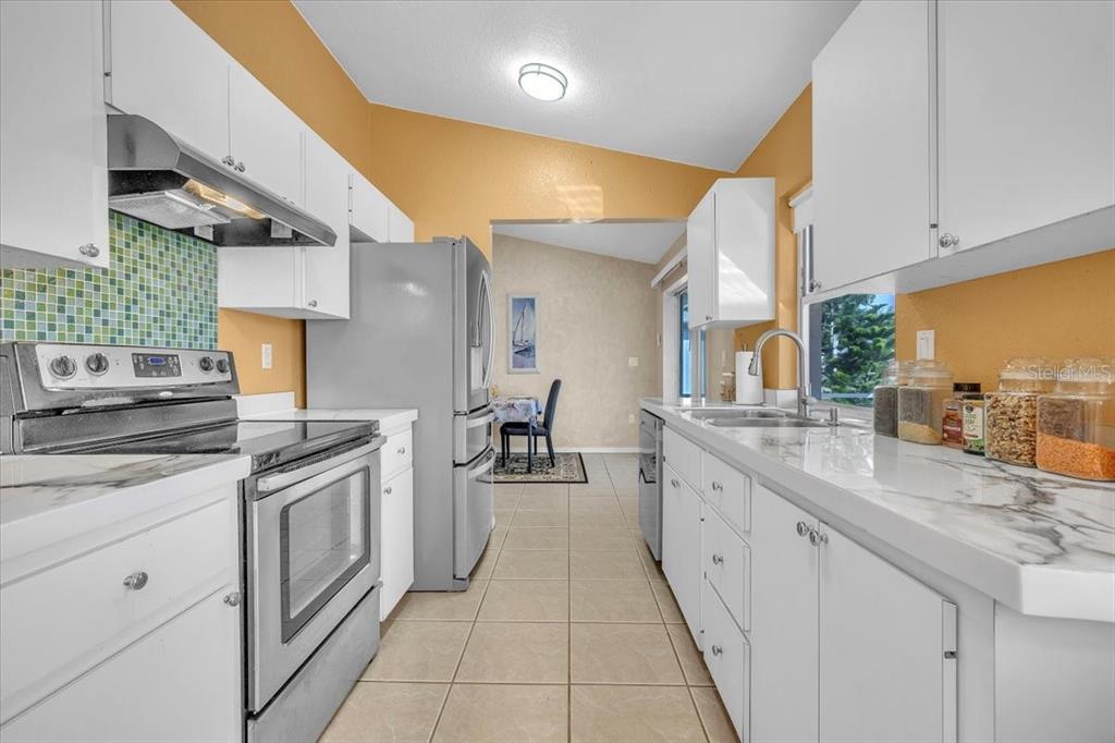 25313 Durango Court Punta Gorda, FL 33955 - Photo 9 of 34 a kitchen with stainless steel appliances granite countertop a sink and cabinets