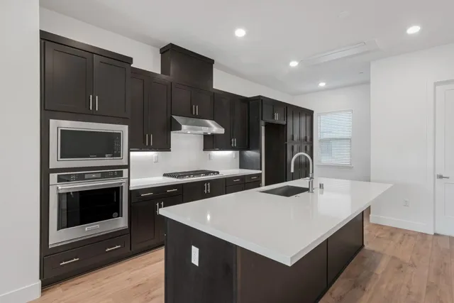 a kitchen that has a sink and a stove top oven