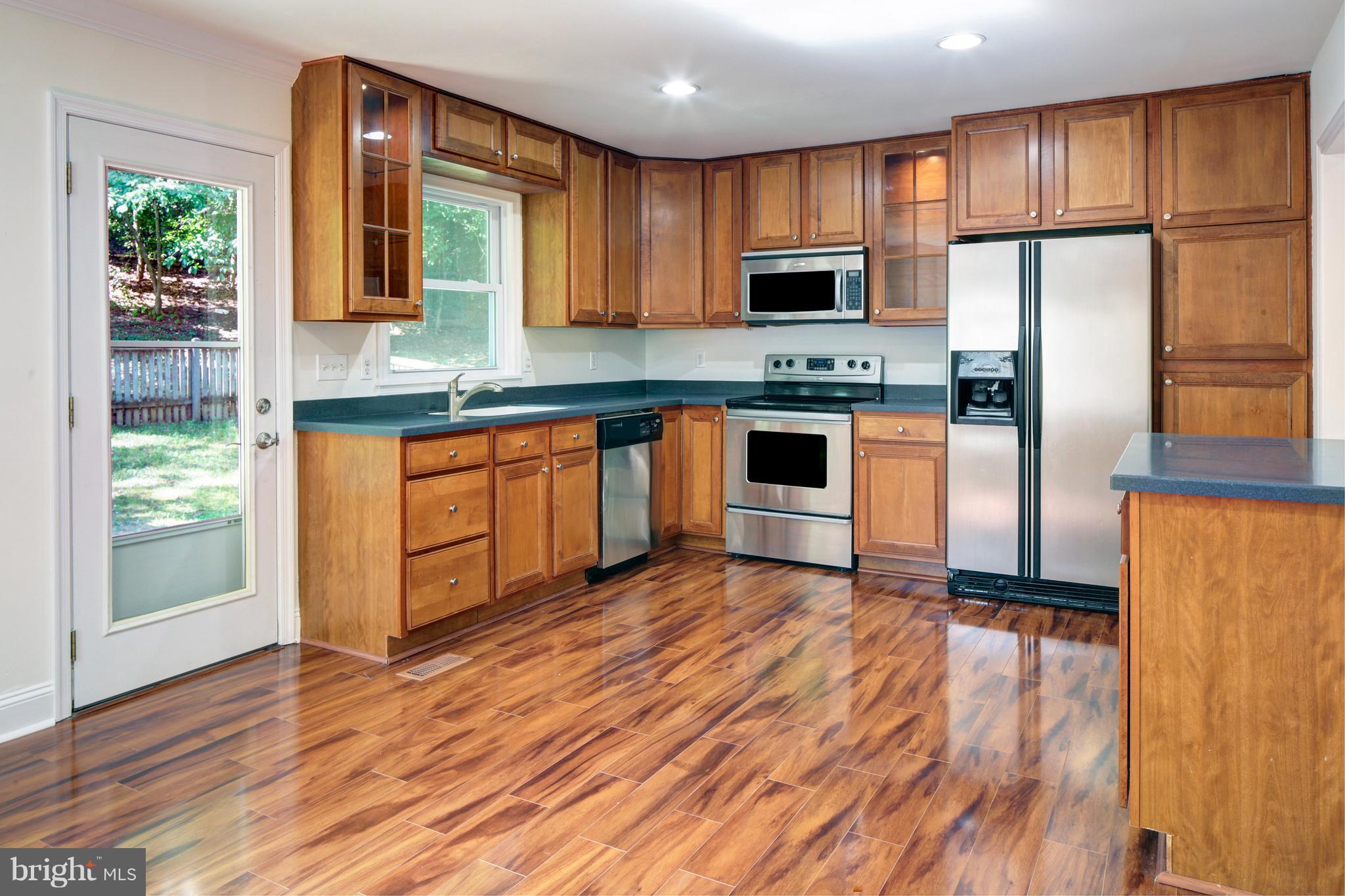 502 Hoot Owl Road Riva, MD 21140 - Photo 6 of 30 a kitchen with stainless steel appliances granite countertop a refrigerator a stove top oven a sink and dishwasher with wooden floor