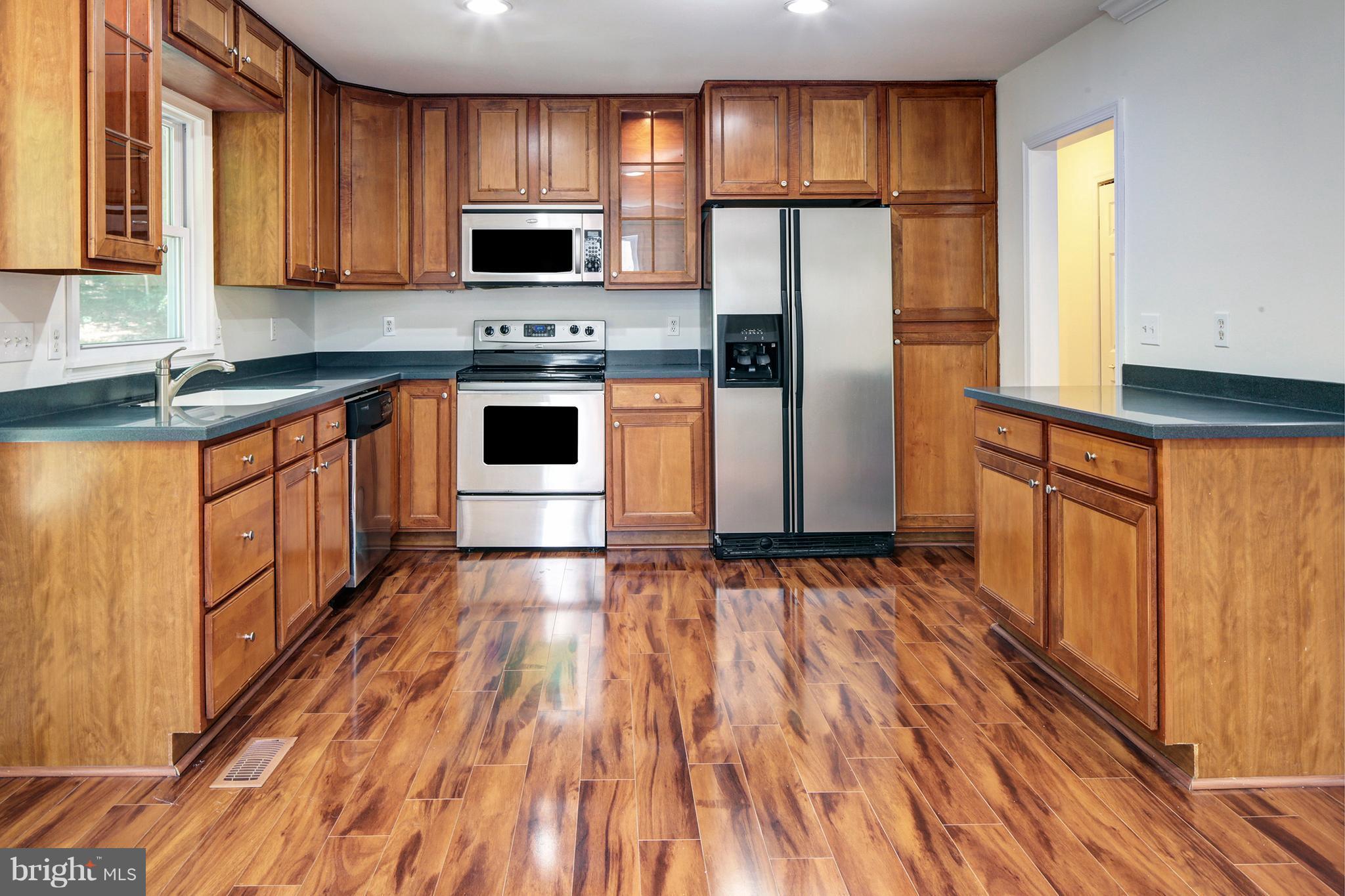 502 Hoot Owl Road Riva, MD 21140 - Photo 7 of 30 a kitchen with granite countertop wooden floors stainless steel appliances a sink and a window