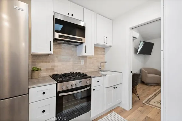 a kitchen with stainless steel appliances a stove a microwave and sink