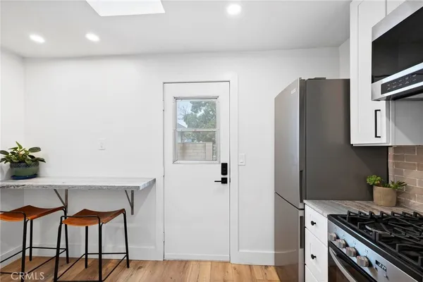 a kitchen with stainless steel appliances granite countertop a refrigerator and a stove top oven