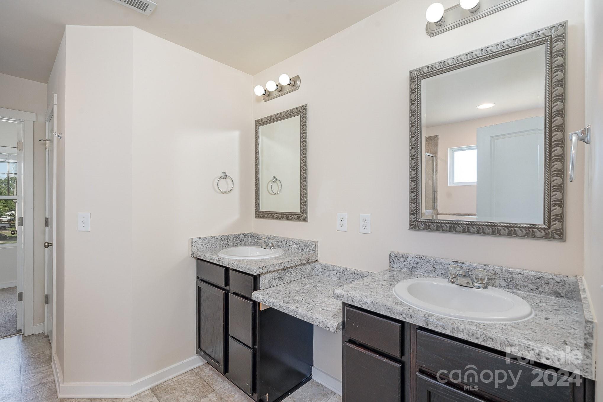 4602 Gibbons Link Road Charlotte, NC 28269 - Photo 20 of 35 a bathroom with a granite countertop sink a mirror and a