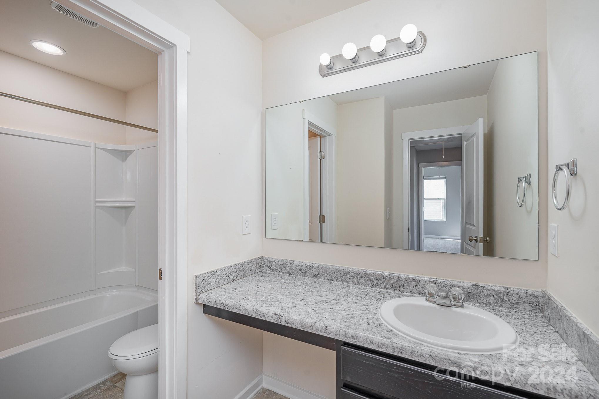 4602 Gibbons Link Road Charlotte, NC 28269 - Photo 27 of 35 a bathroom with a granite countertop sink a toilet and shower