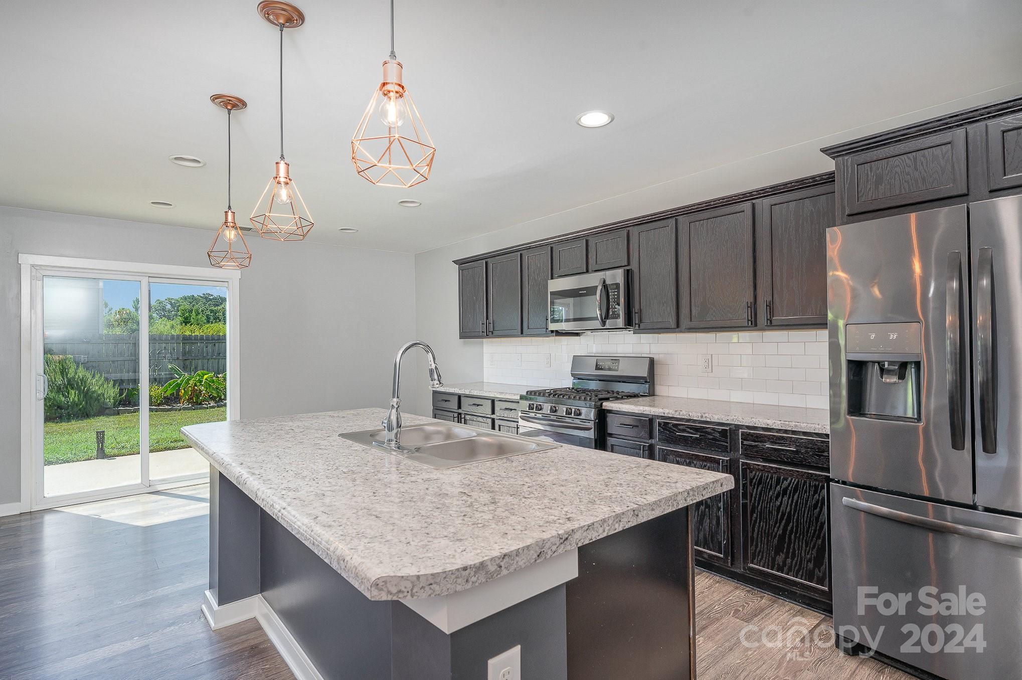 4602 Gibbons Link Road Charlotte, NC 28269 - Photo 8 of 35 a kitchen with stainless steel appliances granite countertop a sink a refrigerator and a stove