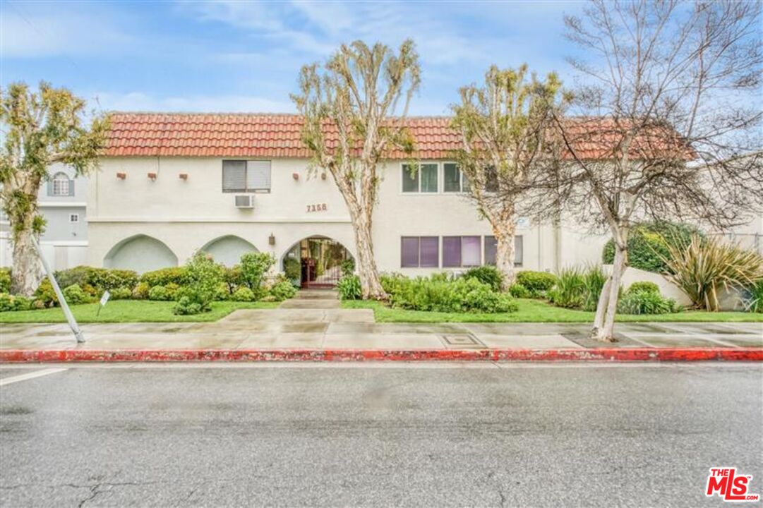 7356 Corbin Avenue Reseda, CA 91335 - Photo 1 of 11 a view of a white house with a large tree and plants