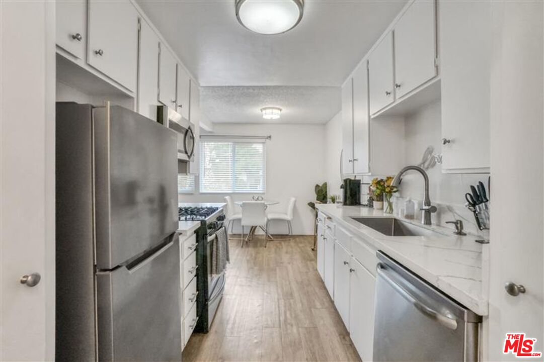 7356 Corbin Avenue Reseda, CA 91335 - Photo 8 of 11 a kitchen with stainless steel appliances a refrigerator sink and stove
