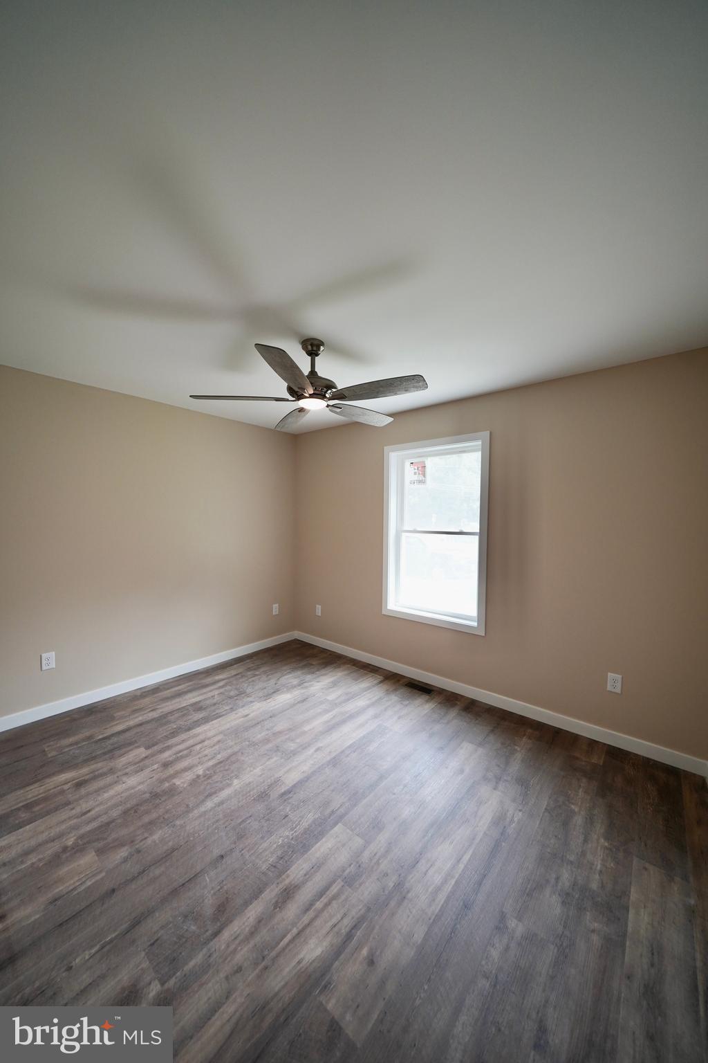 109 Main Street Ellendale, DE 19941 - Photo 15 of 29 an empty room with wooden floor fan and windows