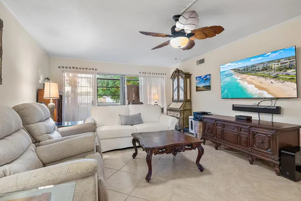 a living room with furniture a window and a flat screen tv