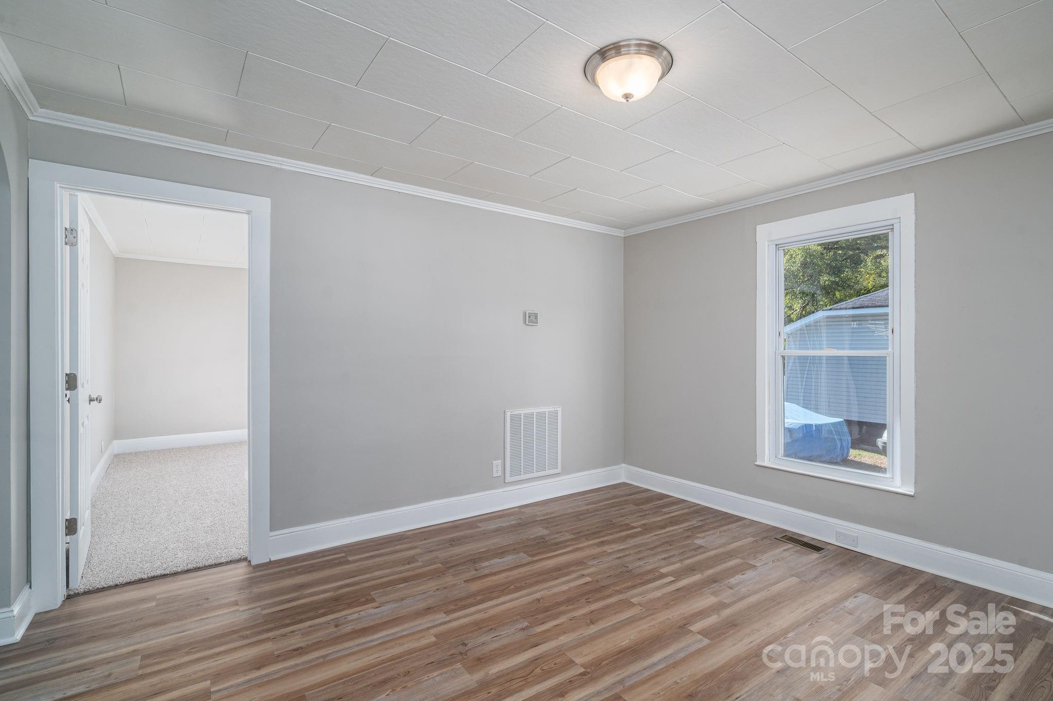 1811 Hemlock Avenue Gastonia, NC 28054 - Photo 11 of 31 an empty room with wooden floor and windows