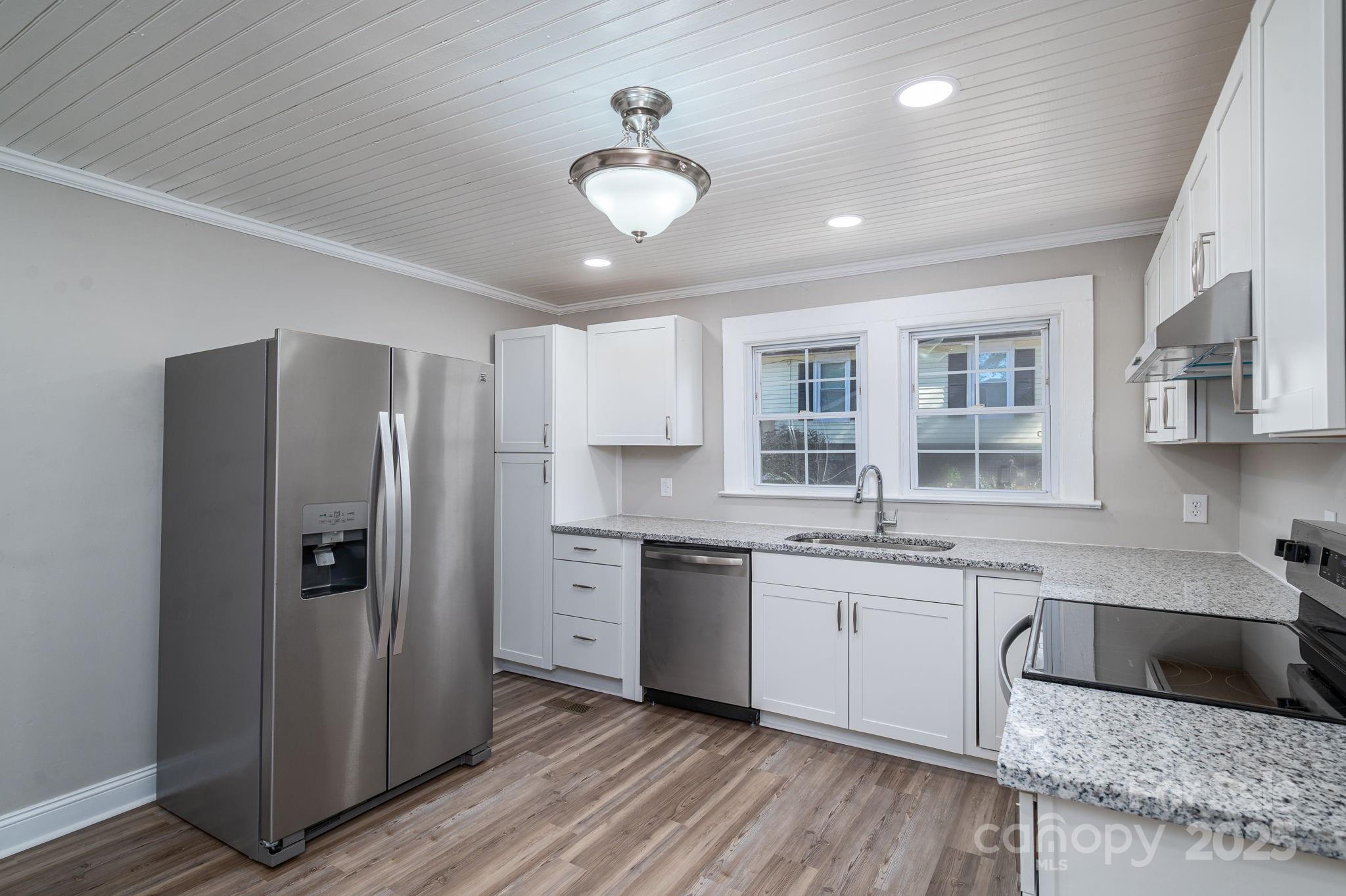 1811 Hemlock Avenue Gastonia, NC 28054 - Photo 19 of 31 a large kitchen with a center island wooden floor and stainless steel appliances