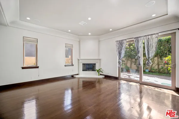 a view of empty room with wooden floor and fireplace