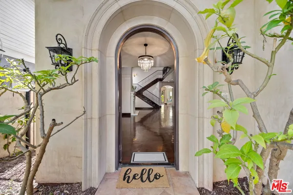 a vase of flowers sitting on a floor in front of a door