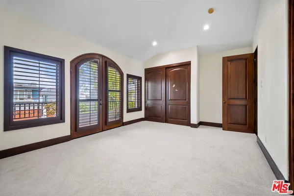 an empty room with windows and closet