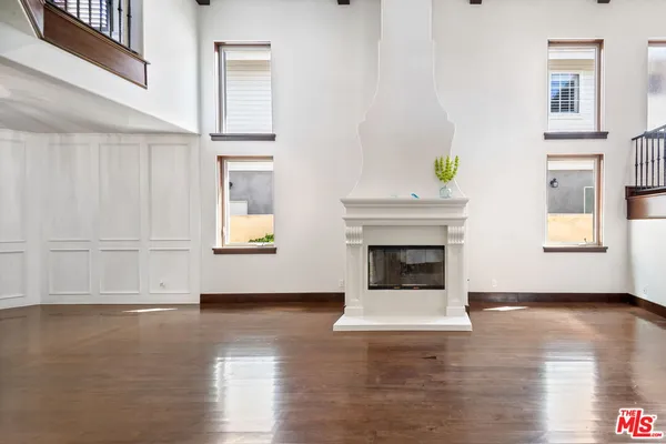 a view of a livingroom with wooden floor and a fireplace