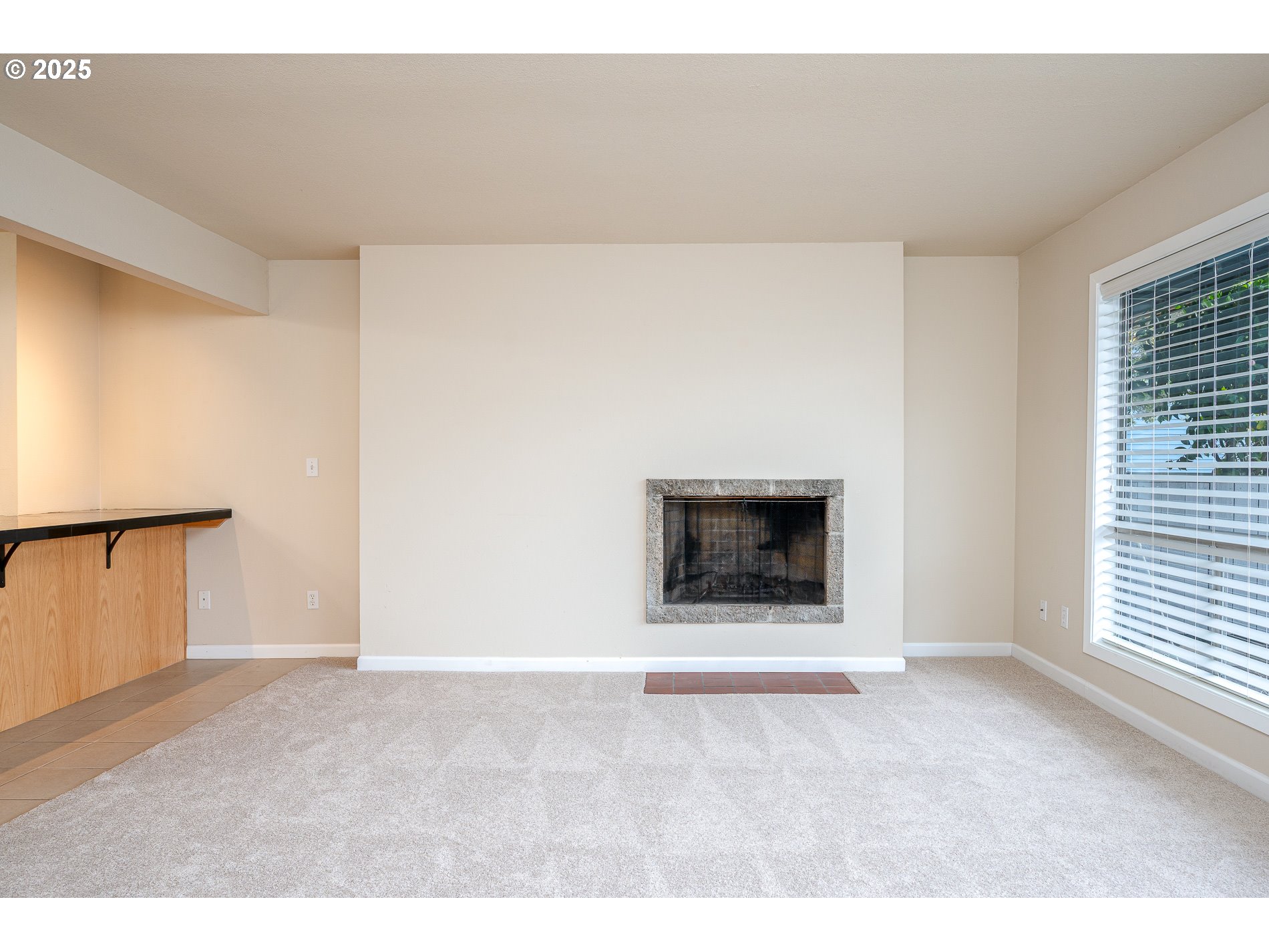 10090 Southwest Beaverton Hillsdale Highway, Unit 16 Beaverton, OR 97005 - Photo 17 of 39 a view of an empty room with a window and fireplace