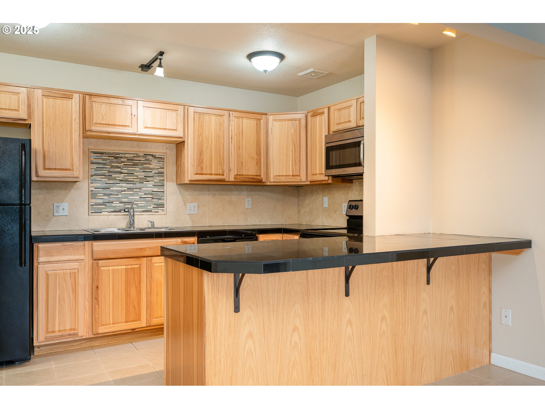 10090 Southwest Beaverton Hillsdale Highway, Unit 16 Beaverton, OR 97005 - Photo 22 of 39 a kitchen with a refrigerator a sink and cabinets