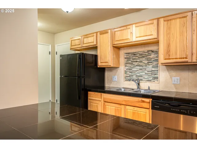 a kitchen with stainless steel appliances granite countertop a refrigerator and a sink