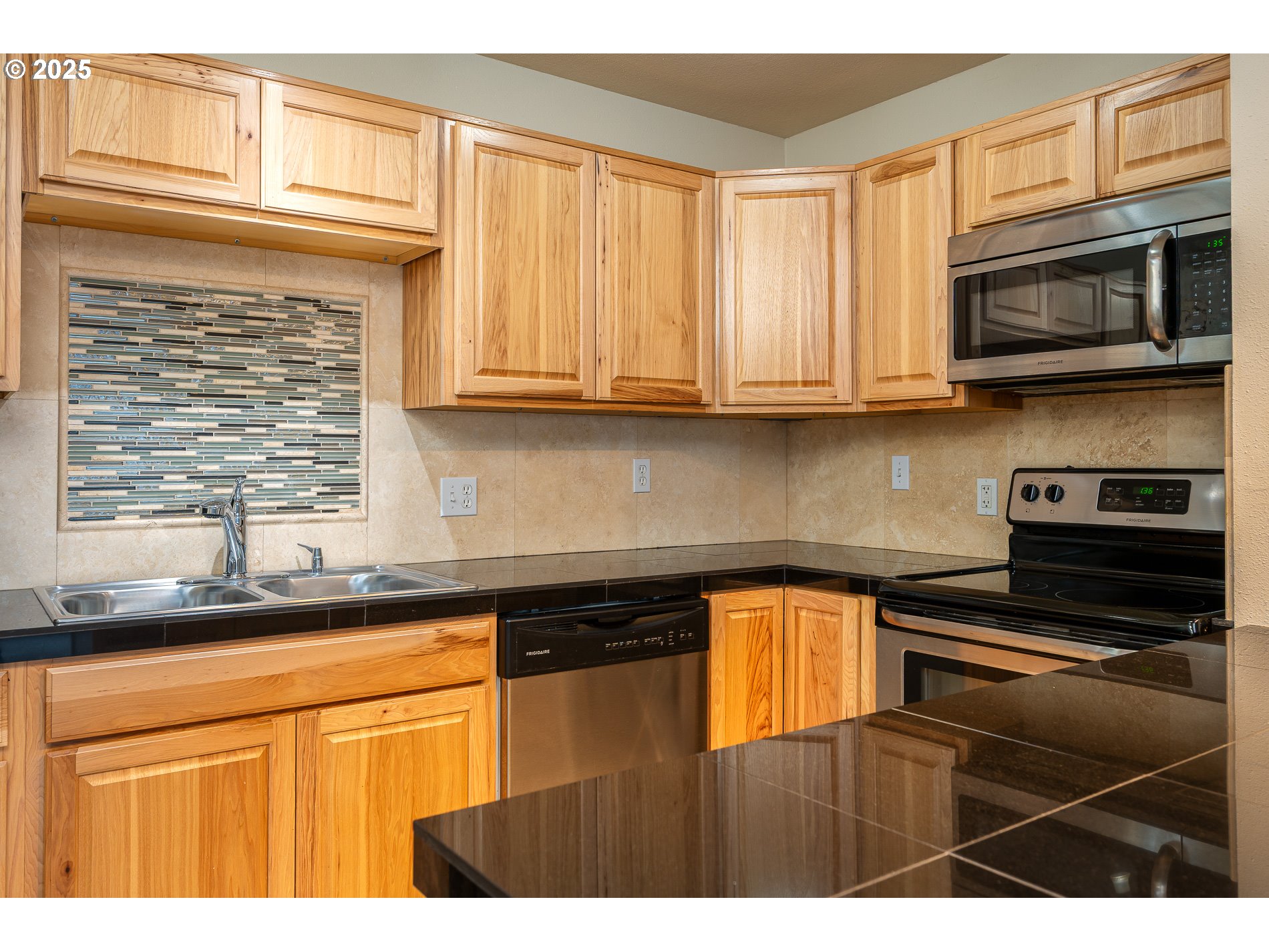 10090 Southwest Beaverton Hillsdale Highway, Unit 16 Beaverton, OR 97005 - Photo 4 of 39 a kitchen with stainless steel appliances granite countertop a sink stove and microwave