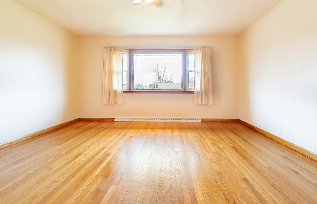 1094 North 3rd Street Rochelle, IL 61068 - Photo 8 of 24 an empty room with wooden floor and windows