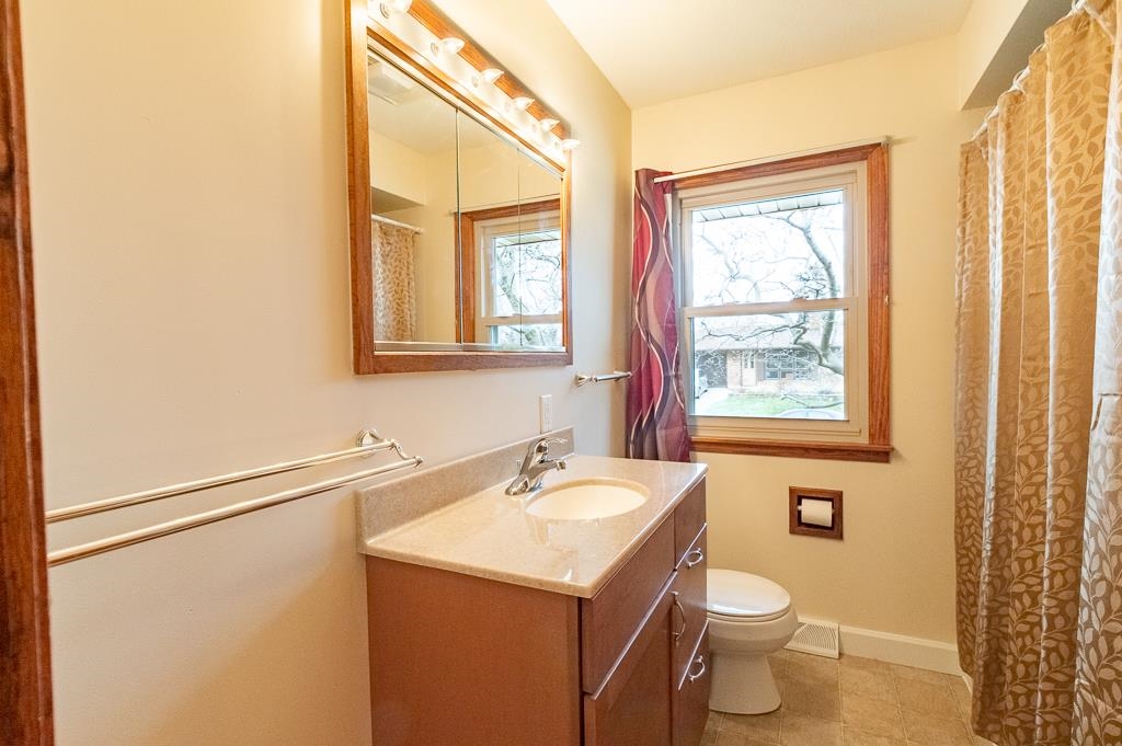 1094 North 3rd Street Rochelle, IL 61068 - Photo 10 of 24 a bathroom with a sink a toilet and a mirror