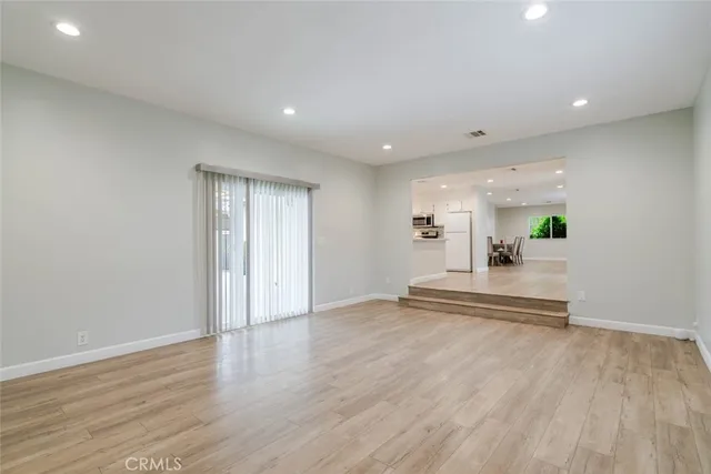 a view of a living room and kitchen with wooden floor