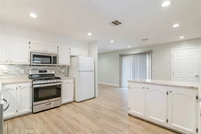 a kitchen with stainless steel appliances granite countertop a stove a sink and a microwave