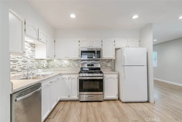 a kitchen with a stove a refrigerator and a sink