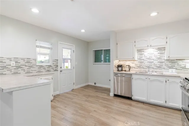 a kitchen with granite countertop white cabinets and white appliances