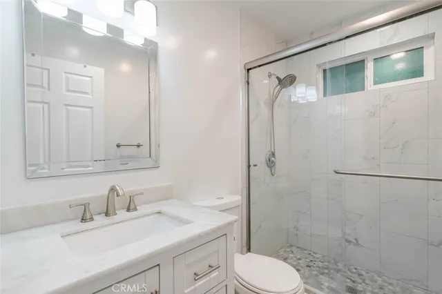 a bathroom with a granite countertop sink toilet and shower