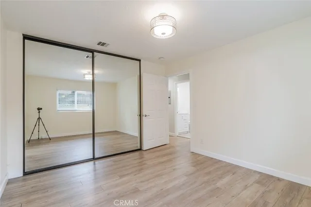 an empty room with wooden floor and a glass door
