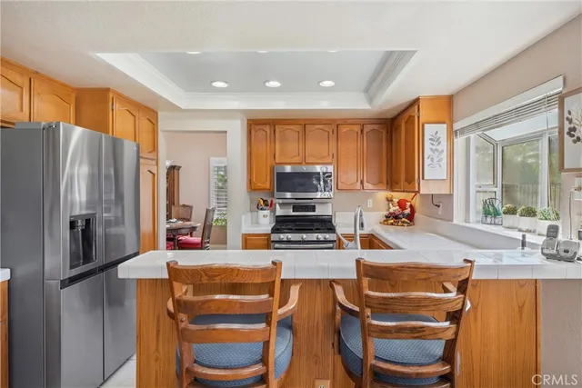 a kitchen with stainless steel appliances granite countertop a refrigerator and a stove top oven