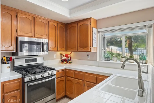 a kitchen with stainless steel appliances granite countertop a stove a sink and a microwave