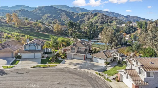 an aerial view of a house with a mountain