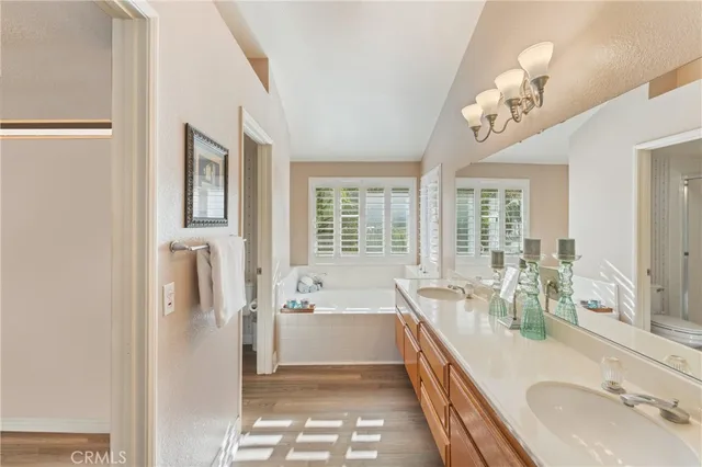 a bathroom with a tub sink and mirror