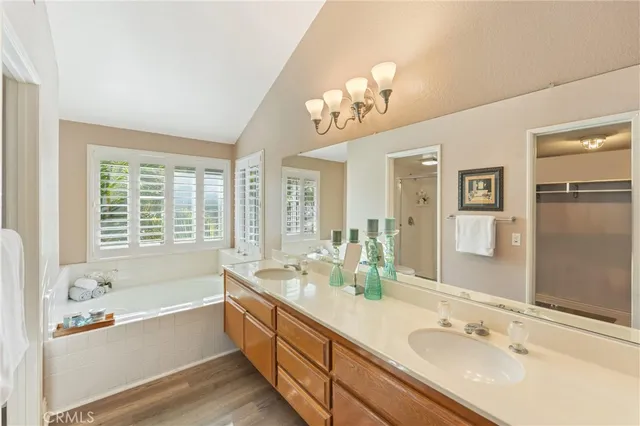 a spacious bathroom with a tub double sink and a mirror