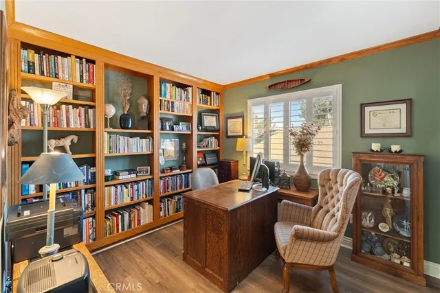 a living room with furniture a bookshelf and a window