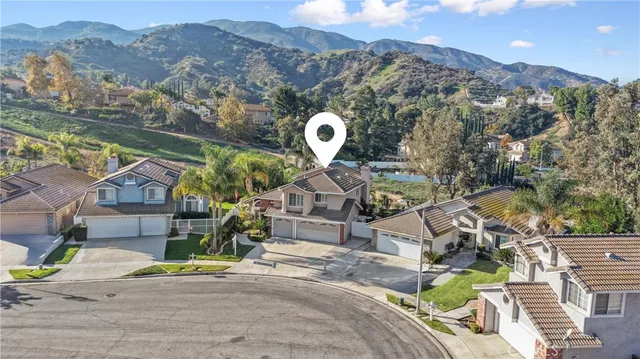 an aerial view of a house with a mountain
